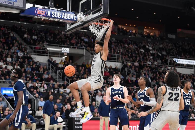 Jan 25, 2023; Providence, Rhode Island, USA; Providence Friars forward Ed Croswell (5) hangs off the basket after dunking against the Butler Bulldogs at Amica Mutual Pavilion. Mandatory Credit: Eric Canha-USA TODAY Sports
