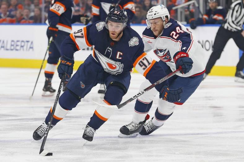 Jan 25, 2023; Edmonton, Alberta, CAN; Edmonton Oilers forward Connor McDavid (97) carries the puck around Columbus Blue Jackets forward Mathieu Olivier (24) during the first period at Rogers Place. Mandatory Credit: Perry Nelson-USA TODAY Sports