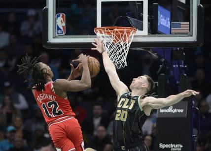 Jan 26, 2023; Charlotte, North Carolina, USA; Chicago Bulls guard Ayo Dosunmu (12) drives in as he is ended by Charlotte Hornets Gordon Hayward (20) during the first half at the Spectrum Center. Mandatory Credit: Sam Sharpe-USA TODAY Sports