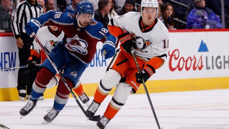 Jan 26, 2023; Denver, Colorado, USA; Anaheim Ducks center Trevor Zegras (11) controls the puck ahead of Colorado Avalanche center Alex Newhook (18) in the first period at Ball Arena. Mandatory Credit: Isaiah J. Downing-USA TODAY Sports