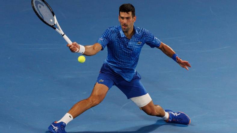 Jan 27, 2023; Melbourne, Victoria, Australia;  Novak Djokovic of Serbia hits a shot against Tommy Paul of the United States on day twelve of the 2023 Australian Open tennis tournament at Melbourne Park. Mandatory Credit: Mike Frey-USA TODAY Sports