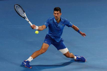 Jan 27, 2023; Melbourne, Victoria, Australia;  Novak Djokovic of Serbia hits a shot against Tommy Paul of the United States on day twelve of the 2023 Australian Open tennis tournament at Melbourne Park. Mandatory Credit: Mike Frey-USA TODAY Sports