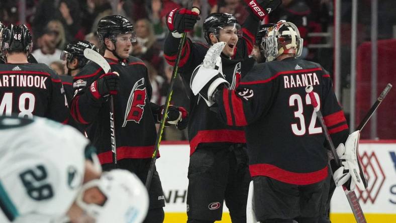 Jan 27, 2023; Raleigh, North Carolina, USA;  Carolina Hurricanes goaltender Antti Raanta (32) and center Martin Necas (88) celebrate their victory against the San Jose Sharks at PNC Arena. Mandatory Credit: James Guillory-USA TODAY Sports