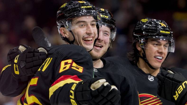 Jan 27, 2023; Vancouver, British Columbia, CAN; Vancouver Canucks forward Ilya Mikheyev (65) celebrates after scoring a goal against the Columbus Blue Jackets with defenseman Ethan Bear (74) and forward Brock Boeser (6) in the first period at Rogers Arena. Mandatory Credit: Bob Frid-USA TODAY Sports