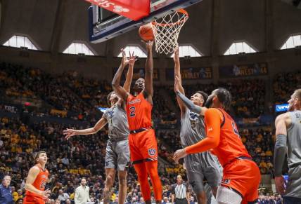 Jan 28, 2023; Morgantown, West Virginia, USA; Auburn Tigers forward Jaylin Williams (2) shoots in the lane against West Virginia Mountaineers forward Emmitt Matthews Jr. (1) and forward Tre Mitchell (3) during the first half at WVU Coliseum. Mandatory Credit: Ben Queen-USA TODAY Sports