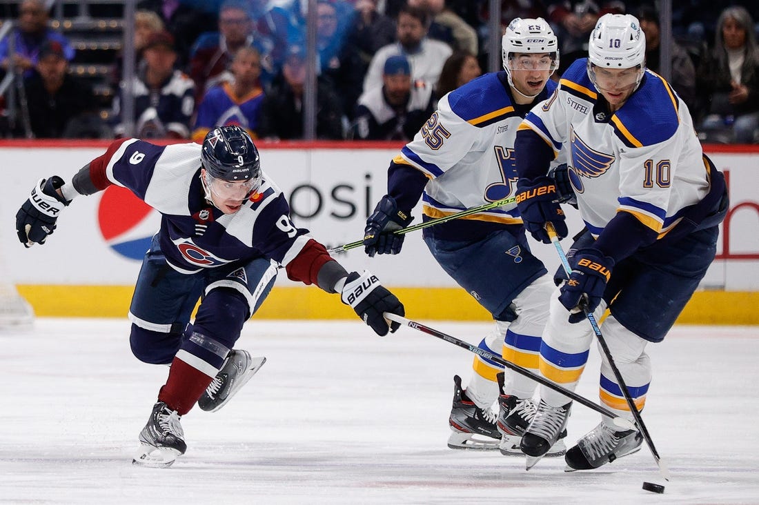 Jan 28, 2023; Denver, Colorado, USA; St. Louis Blues center Brayden Schenn (10) controls the puck under pressure from Colorado Avalanche center Evan Rodrigues (9) as center Jordan Kyrou (25) looks on in the first period at Ball Arena. Mandatory Credit: Isaiah J. Downing-USA TODAY Sports