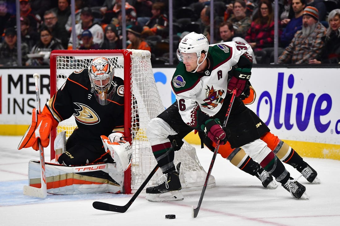 Jan 28, 2023; Anaheim, California, USA; Arizona Coyotes right wing Christian Fischer (36) moves the puck as Anaheim Ducks goaltender John Gibson (36) defends the goal during the first period at Honda Center. Mandatory Credit: Gary A. Vasquez-USA TODAY Sports