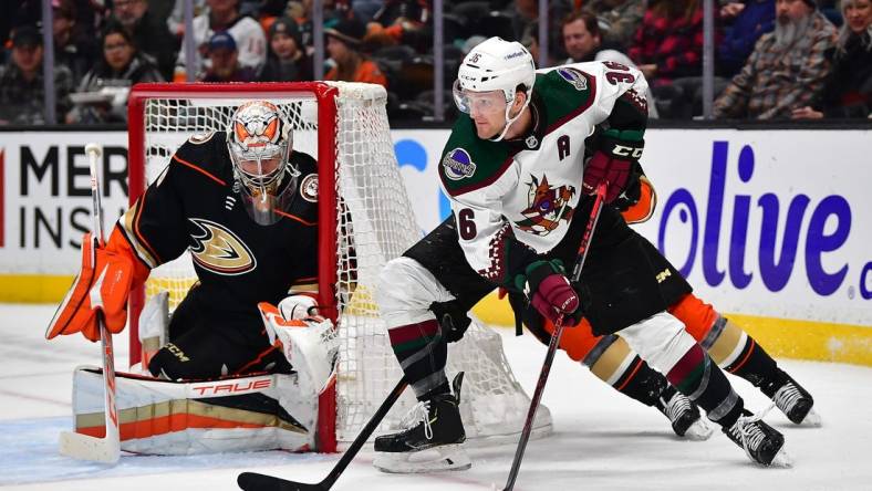 Jan 28, 2023; Anaheim, California, USA; Arizona Coyotes right wing Christian Fischer (36) moves the puck as Anaheim Ducks goaltender John Gibson (36) defends the goal during the first period at Honda Center. Mandatory Credit: Gary A. Vasquez-USA TODAY Sports