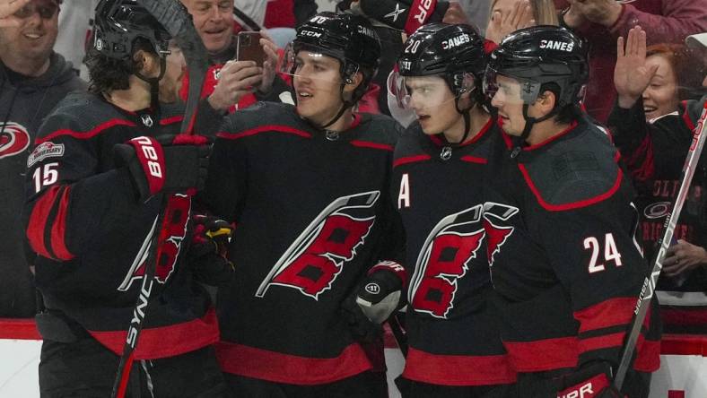 Jan 29, 2023; Raleigh, North Carolina, USA;  Carolina Hurricanes center Sebastian Aho (20) is congratulated by  center Seth Jarvis (24) left wing Teuvo Teravainen (86) and defenseman Dylan Coghlan (15) after his goal against the Boston Bruins during the first period at PNC Arena. Mandatory Credit: James Guillory-USA TODAY Sports