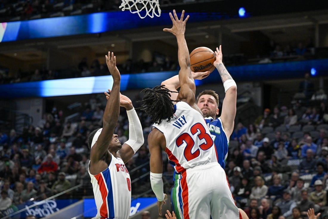 Jan 30, 2023; Dallas, Texas, USA; Dallas Mavericks guard Luka Doncic (77) looks to passes the ball over Detroit Pistons guard Jaden Ivey (23) and center Jalen Duren (0) during the first quarter at the American Airlines Center. Mandatory Credit: Jerome Miron-USA TODAY Sports