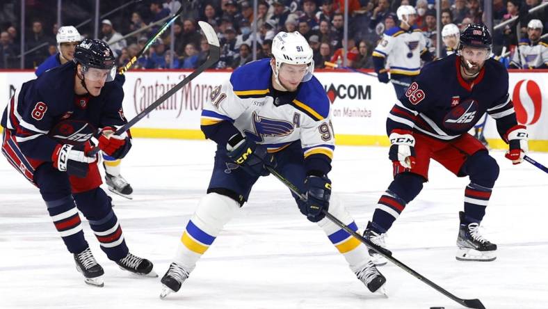 Jan 30, 2023; Winnipeg, Manitoba, CAN; St. Louis Blues right wing Vladimir Tarasenko (91) skates between Winnipeg Jets right wing Saku Maenalanen (8) and Winnipeg Jets center Sam Gagner (89) in the first period at Canada Life Centre. Mandatory Credit: James Carey Lauder-USA TODAY Sports