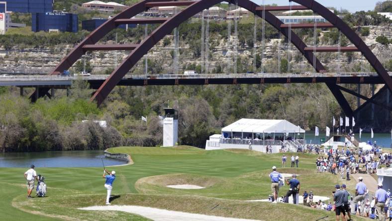 Mar 25, 2021; Austin, Texas, USA; Bryson DeChambeau hits his approach on #12 during the second day of the WGC Dell Technologies Match Play golf tournament at Austin Country Club. The Pennybacker Bridge, one of the signature landmarks of Austin, spans Lake Austin in the background. Mandatory Credit: Erich Schlegel-USA TODAY Sports