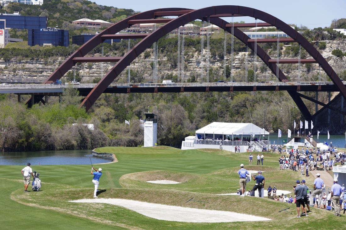 Mar 25, 2021; Austin, Texas, USA; Bryson DeChambeau hits his approach on #12 during the second day of the WGC Dell Technologies Match Play golf tournament at Austin Country Club. The Pennybacker Bridge, one of the signature landmarks of Austin, spans Lake Austin in the background. Mandatory Credit: Erich Schlegel-USA TODAY Sports