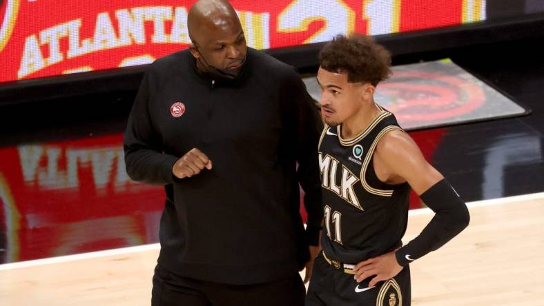 May 5, 2021; Atlanta, Georgia, USA; Atlanta Hawks coach Nate McMillan talks with guard Trae Young (11) during a time out of their game against the Phoenix Suns at State Farm Arena. Mandatory Credit: Jason Getz-USA TODAY Sports