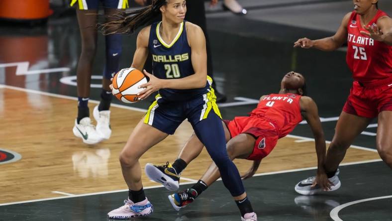 May 27, 2021; College Park, Georgia, USA; Atlanta Dream guard Aari McDonald (4) is knocked to the court by Dallas Wings forward Isabelle Harrison (20) during the first half at Gateway Center Arena at College Park. Mandatory Credit: Dale Zanine-USA TODAY Sports