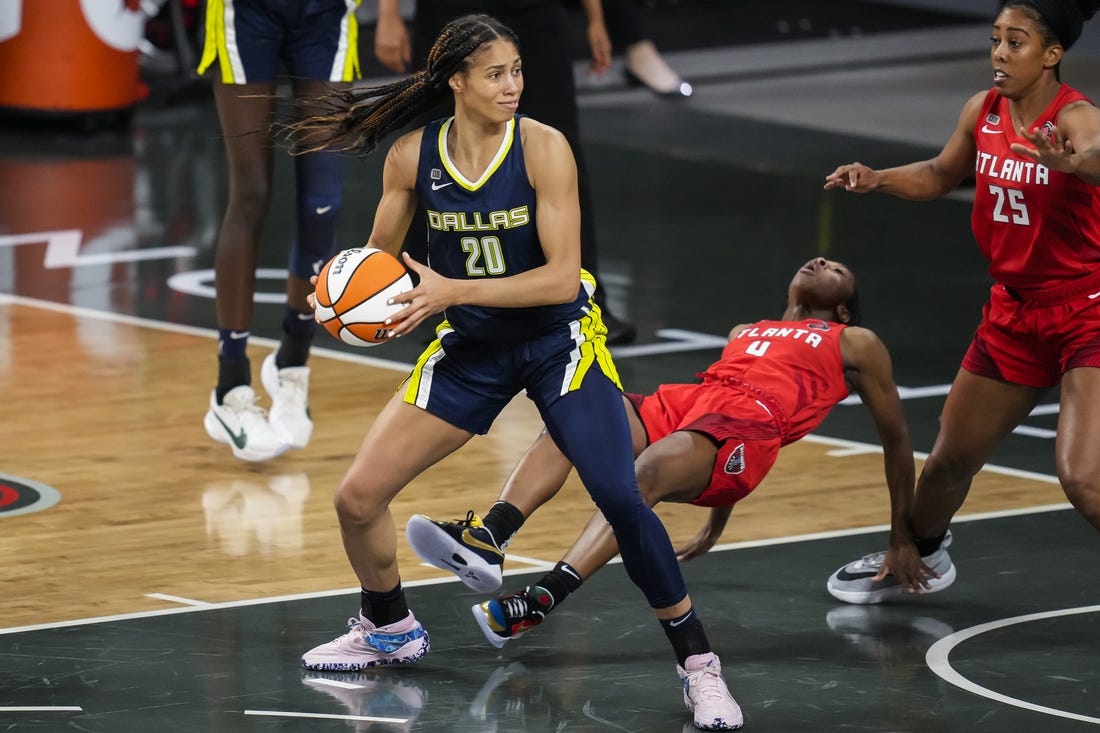 May 27, 2021; College Park, Georgia, USA; Atlanta Dream guard Aari McDonald (4) is knocked to the court by Dallas Wings forward Isabelle Harrison (20) during the first half at Gateway Center Arena at College Park. Mandatory Credit: Dale Zanine-USA TODAY Sports