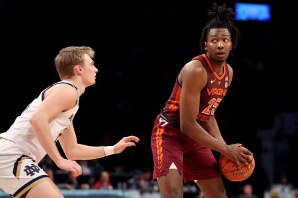 Mar 10, 2022; Brooklyn, NY, USA; Virginia Tech Hokies forward Justyn Mutts (25) controls the ball against Notre Dame Fighting Irish guard Dane Goodwin (23) during the second half at Barclays Center. Mandatory Credit: Brad Penner-USA TODAY Sports