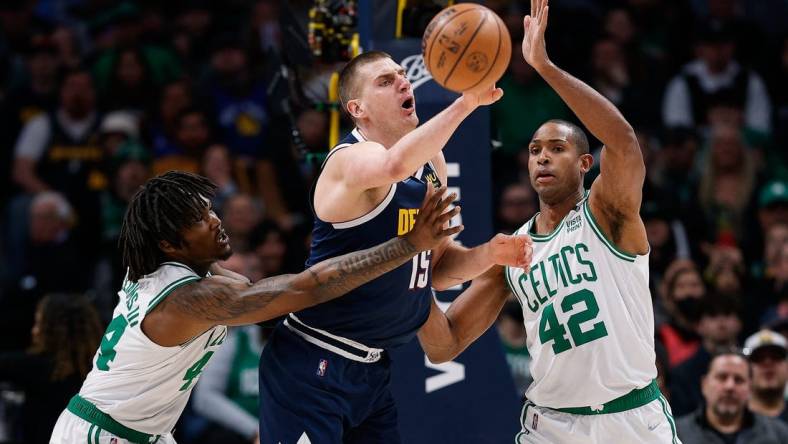 Mar 20, 2022; Denver, Colorado, USA; Denver Nuggets center Nikola Jokic (15) looks to pass the ball under pressure from Boston Celtics center Robert Williams III (44) and center Al Horford (42) in the first quarter at Ball Arena. Mandatory Credit: Isaiah J. Downing-USA TODAY Sports