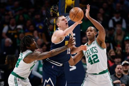 Mar 20, 2022; Denver, Colorado, USA; Denver Nuggets center Nikola Jokic (15) looks to pass the ball under pressure from Boston Celtics center Robert Williams III (44) and center Al Horford (42) in the first quarter at Ball Arena. Mandatory Credit: Isaiah J. Downing-USA TODAY Sports