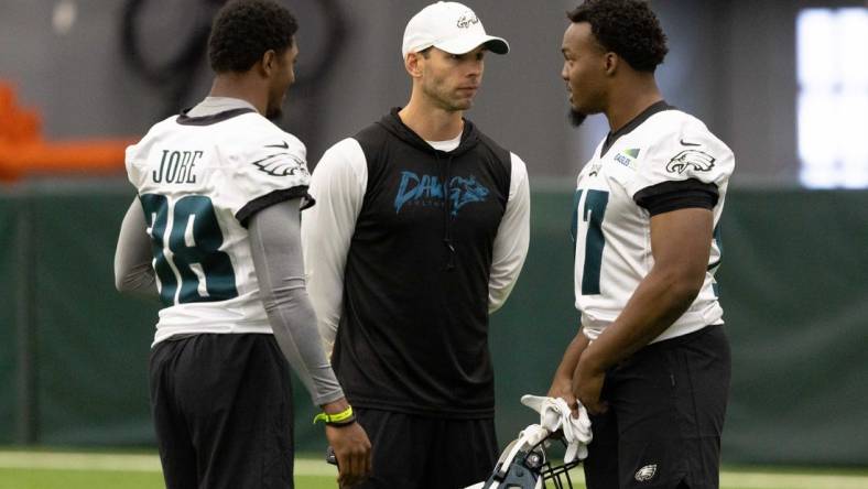 May 6, 2022; Philadelphia, PA, USA; Philadelphia Eagles linebacker Nakobe Deean (R) and defensive back Josh Jobe (L) talk with defensive coordinator Jonathan Gannon (M) during Rookie Minicamp at NovaCare Complex. Mandatory Credit: Bill Streicher-USA TODAY Sports