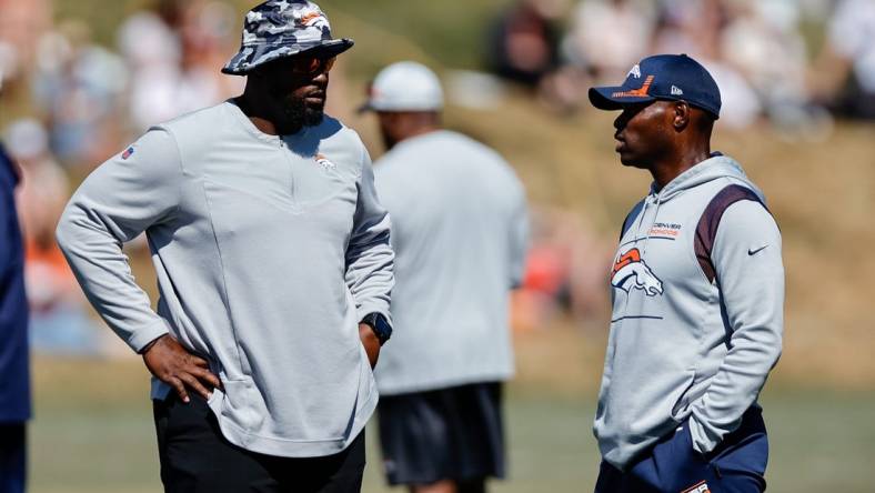 Aug 10, 2022; Englewood, CO, USA; Denver Broncos defensive line coach Marcus Dixon (L) talks with defensive coordinator Ejiro Evero (R) during training camp at the UCHealth Training Center. Mandatory Credit: Isaiah J. Downing-USA TODAY Sports