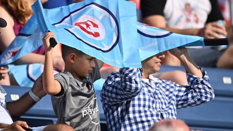 Aug 21, 2022; Chicago, Illinois, USA;  Fans shield themselves from the sun using their Chicago Fire FC flags during the first half of a game against New York City FC at Bridgeview Stadium. Mandatory Credit: Jamie Sabau-USA TODAY Sports