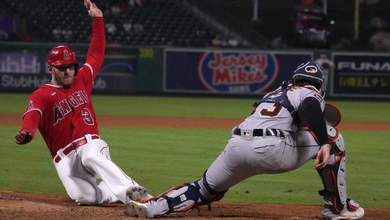 Sep 6, 2022; Anaheim, California, USA; Los Angeles Angels right fielder Taylor Ward (3) slides into home plate to beat a throw to Detroit Tigers catcher Tucker Barnhart (15) to score in the 10th inning at Angel Stadium. Mandatory Credit: Kirby Lee-USA TODAY Sports