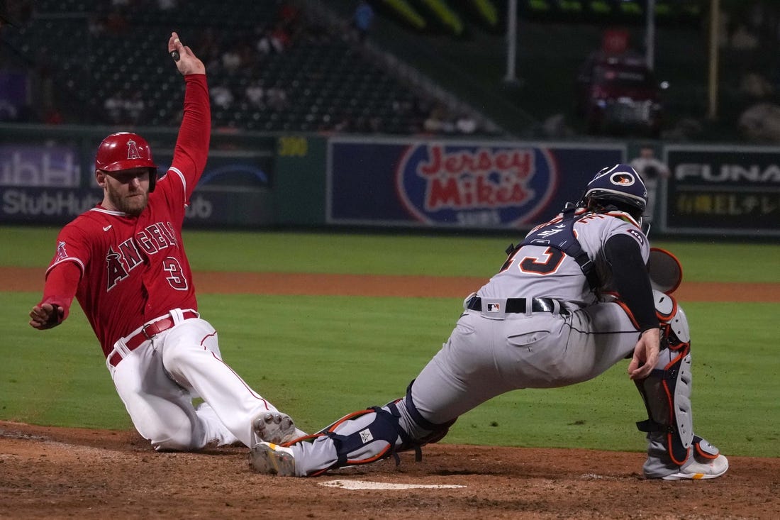 Sep 6, 2022; Anaheim, California, USA; Los Angeles Angels right fielder Taylor Ward (3) slides into home plate to beat a throw to Detroit Tigers catcher Tucker Barnhart (15) to score in the 10th inning at Angel Stadium. Mandatory Credit: Kirby Lee-USA TODAY Sports