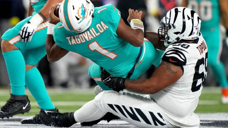 Sep 29, 2022; Cincinnati, Ohio, USA; Cincinnati Bengals defensive tackle Josh Tupou (68) sacks Miami Dolphins quarterback Tua Tagovailoa (1) in the second quarter at Paycor Stadium in Cincinnati. Tagovailoa sustained a head injury on the play and left the game for treatment. Mandatory Credit: Kareem Elgazzar-USA TODAY Sports