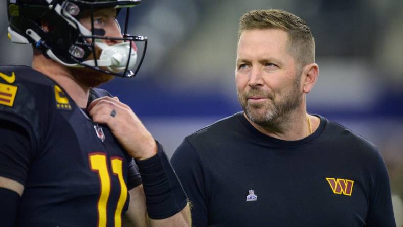 Oct 2, 2022; Arlington, Texas, USA; Washington Commanders quarterback Carson Wentz (left) talks with offensive coordinator Scott Turner (right) before the game between the Dallas Cowboys and the Washington Commanders at AT&T Stadium. Mandatory Credit: Jerome Miron-USA TODAY Sports