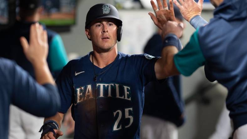 Oct 3, 2022; Seattle, Washington, USA; Seattle Mariners right fielder Dylan Moore (25) celebrates in the dugout after scoring a run against the Detroit Tigers during the fifth inning at T-Mobile Park. Mandatory Credit: Steven Bisig-USA TODAY Sports