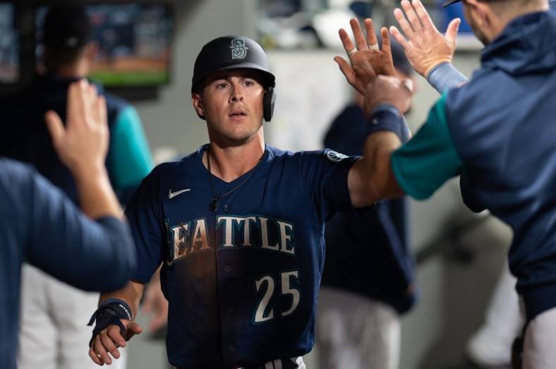 Oct 3, 2022; Seattle, Washington, USA; Seattle Mariners right fielder Dylan Moore (25) celebrates in the dugout after scoring a run against the Detroit Tigers during the fifth inning at T-Mobile Park. Mandatory Credit: Steven Bisig-USA TODAY Sports