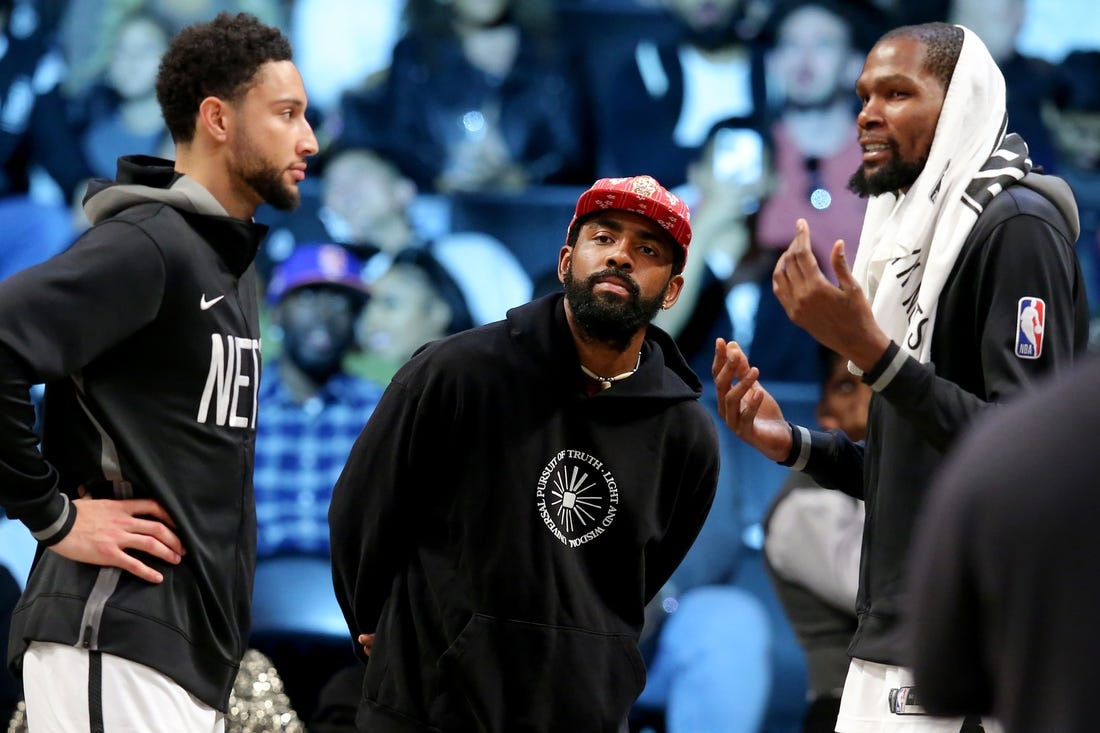 Oct 6, 2022; Brooklyn, New York, USA; Brooklyn Nets guard Kyrie Irving (center) talks to guard Ben Simmons (left) and forward Kevin Durant (7) during the fourth quarter against the Miami Heat at Barclays Center. Mandatory Credit: Brad Penner-USA TODAY Sports