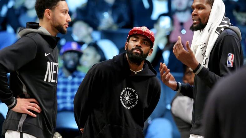 Oct 6, 2022; Brooklyn, New York, USA; Brooklyn Nets guard Kyrie Irving (center) talks to guard Ben Simmons (left) and forward Kevin Durant (7) during the fourth quarter against the Miami Heat at Barclays Center. Mandatory Credit: Brad Penner-USA TODAY Sports