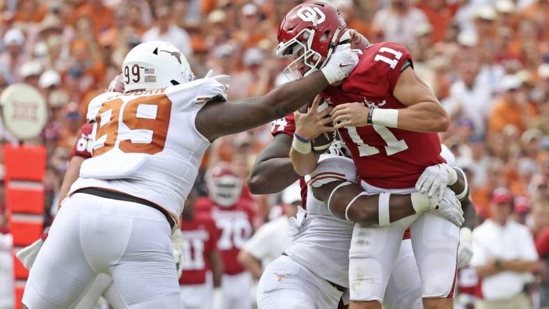 Oct 8, 2022; Dallas, Texas, USA;  Texas Longhorns defensive end Justice Finkley (1) and Texas Longhorns defensive lineman Keondre Coburn (99) sack Oklahoma Sooners quarterback Davis Beville (11) during the second half at the Cotton Bowl. Mandatory Credit: Kevin Jairaj-USA TODAY Sports