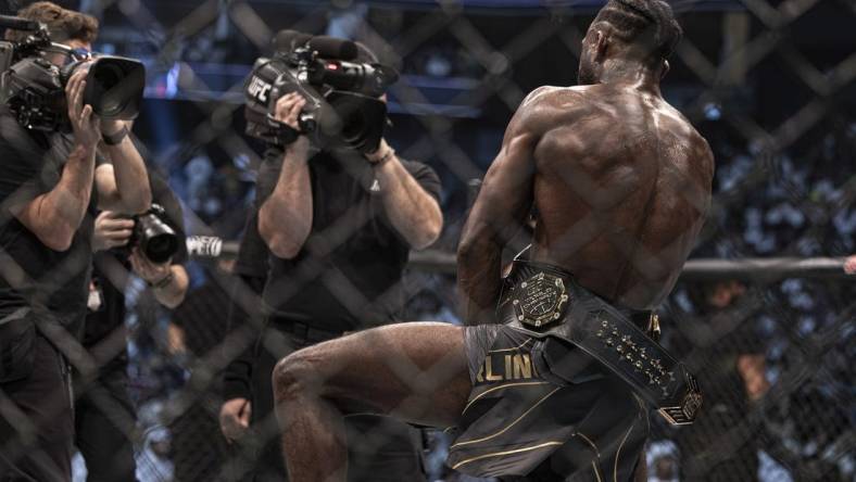 Oct 22, 2022; Abu Dhabi, UAE; Aljamain Sterling (red gloves) celebrates with the title belt after defeating T.J. Dillashaw (blue gloves) during UFC 280 at Etihad Arena. Mandatory Credit: Craig Kidwell-USA TODAY Sports