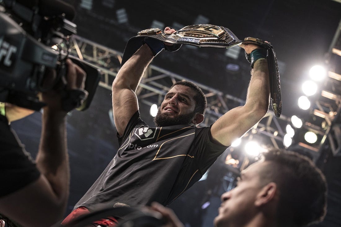 Oct 22, 2022; Abu Dhabi, UAE;   Islam Makhachev (blue gloves) celebrates with the title belt after defeating Charles Oliveira (red gloves) during UFC 280 at Etihad Arena. Mandatory Credit: Craig Kidwell-USA TODAY Sports