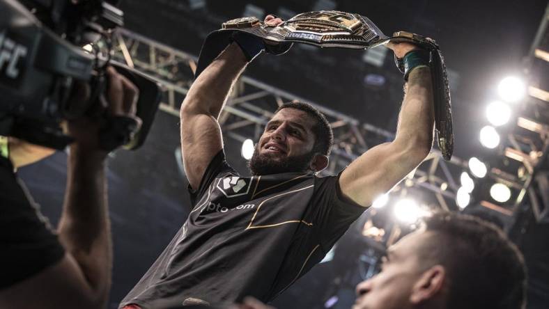 Oct 22, 2022; Abu Dhabi, UAE;   Islam Makhachev (blue gloves) celebrates with the title belt after defeating Charles Oliveira (red gloves) during UFC 280 at Etihad Arena. Mandatory Credit: Craig Kidwell-USA TODAY Sports