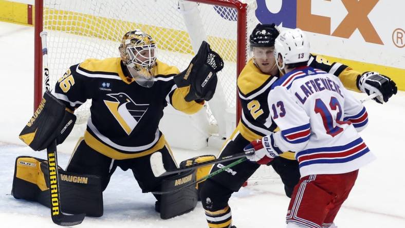 Dec 20, 2022; Pittsburgh, Pennsylvania, USA;  Pittsburgh Penguins goaltender Tristan Jarry (35) makes a glove save as Pens defenseman Chad Ruhwedel (2) defends New York Rangers left wing Alexis Lafreni  re (13) during the second period at PPG Paints Arena. Mandatory Credit: Charles LeClaire-USA TODAY Sports