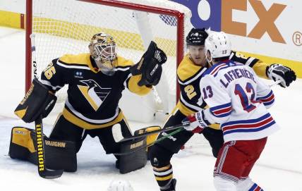 Dec 20, 2022; Pittsburgh, Pennsylvania, USA;  Pittsburgh Penguins goaltender Tristan Jarry (35) makes a glove save as Pens defenseman Chad Ruhwedel (2) defends New York Rangers left wing Alexis Lafreni  re (13) during the second period at PPG Paints Arena. Mandatory Credit: Charles LeClaire-USA TODAY Sports