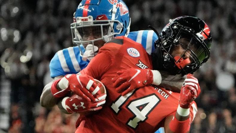 Dec 28, 2022; Houston, Texas, USA;  Texas Tech Red Raiders wide receiver Xavier White (14) is tackled by Mississippi Rebels cornerback Davison Igbinosun (20) in the second half in the 2022 Texas Bowl at NRG Stadium. Mandatory Credit: Thomas Shea-USA TODAY Sports