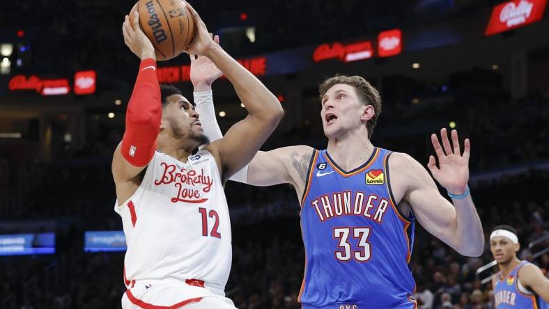 Dec 31, 2022; Oklahoma City, Oklahoma, USA; Philadelphia 76ers forward Tobias Harris (12) shoots the ball against Oklahoma City Thunder center Mike Muscala (33) during the second quarter at Paycom Center. Mandatory Credit: Alonzo Adams-USA TODAY Sports