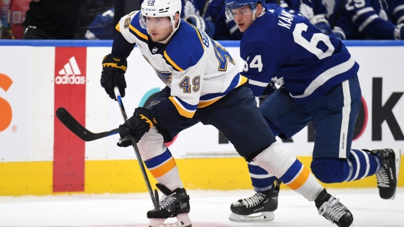 Jan 3, 2023; Toronto, Ontario, CAN;  St. Louis Blues forward Ivan Barbashev (49) skates the puck away from Toronto Maple Leafs forward David Kampf (64) in the second period at Scotiabank Arena. Mandatory Credit: Dan Hamilton-USA TODAY Sports