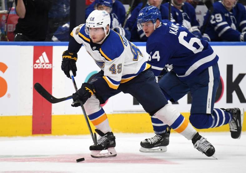 Jan 3, 2023; Toronto, Ontario, CAN;  St. Louis Blues forward Ivan Barbashev (49) skates the puck away from Toronto Maple Leafs forward David Kampf (64) in the second period at Scotiabank Arena. Mandatory Credit: Dan Hamilton-USA TODAY Sports