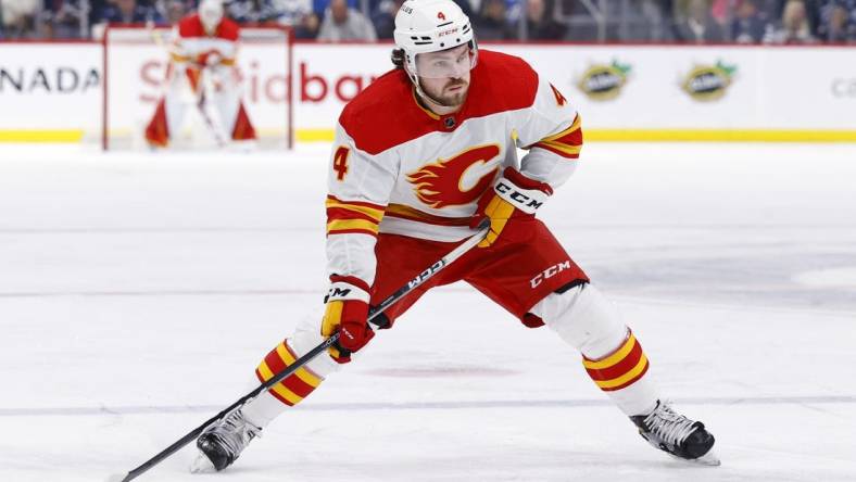 Jan 3, 2023; Winnipeg, Manitoba, CAN;  Calgary Flames defenseman Rasmus Andersson (4) skates with the puck in the first period against the Winnipeg Jets at Canada Life Centre. Mandatory Credit: James Carey Lauder-USA TODAY Sports