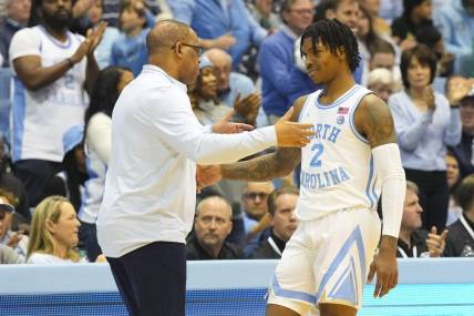 Jan 7, 2023; Chapel Hill, North Carolina, USA;  North Carolina Tar Heels coach Hubert Davis greets guard Caleb Love (2) after he come out of the game against the Notre Dame Fighting Irish during the second half at Dean E. Smith Center. Mandatory Credit: James Guillory-USA TODAY Sports