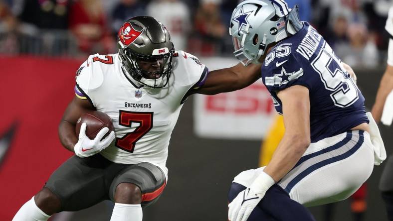 Jan 16, 2023; Tampa, Florida, USA; Tampa Bay Buccaneers running back Leonard Fournette (7) rushes the ball against the Dallas Cowboys linebacker Leighton Vander Esch (55) in the first half during the wild card game at Raymond James Stadium. Mandatory Credit: Kim Klement-USA TODAY Sports