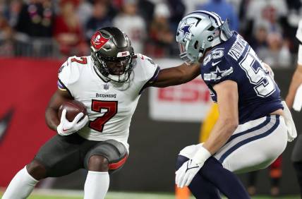 Jan 16, 2023; Tampa, Florida, USA; Tampa Bay Buccaneers running back Leonard Fournette (7) rushes the ball against the Dallas Cowboys linebacker Leighton Vander Esch (55) in the first half during the wild card game at Raymond James Stadium. Mandatory Credit: Kim Klement-USA TODAY Sports