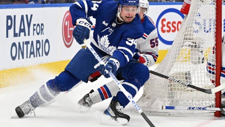 Jan 25, 2023; Toronto, Ontario, CAN;   Toronto Maple Leafs forward Auston Matthews (34) skates with the puck as New York Rangers defenseman Ryan Lindgren (55) defends in the third period at Scotiabank Arena. Mandatory Credit: Dan Hamilton-USA TODAY Sports