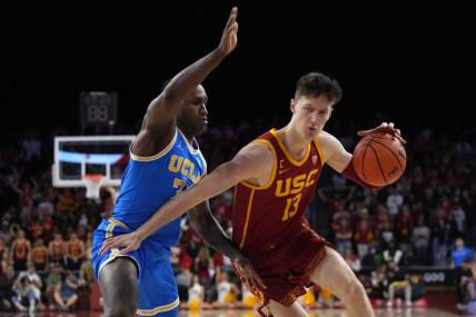 Jan 26, 2023; Los Angeles, California, USA; Southern California Trojans guard Drew Peterson (13) dribbles the ball against UCLA Bruins guard David Singleton (34) in the second half at Galen Center. Mandatory Credit: Kirby Lee-USA TODAY Sports